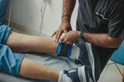 Physiotherapist Standing over Patient Lying Down Physiotherapist Standing over Patient Lying Down