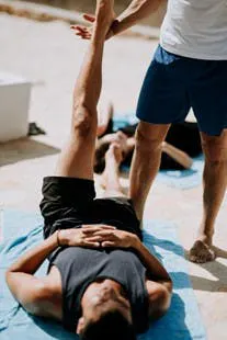 man lying on floor near man standing holding his leg man lying on floor near man standing holding his leg